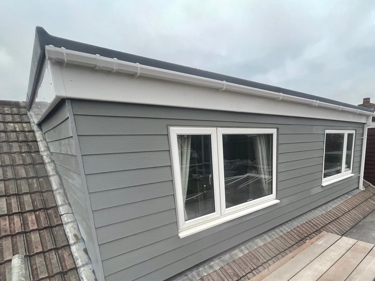 A dormer clad in grey weatherboard by District Roofing
