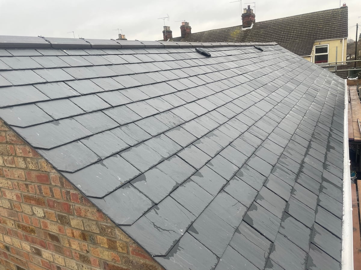 A hipped roof in natural slate, finished by District Roofing