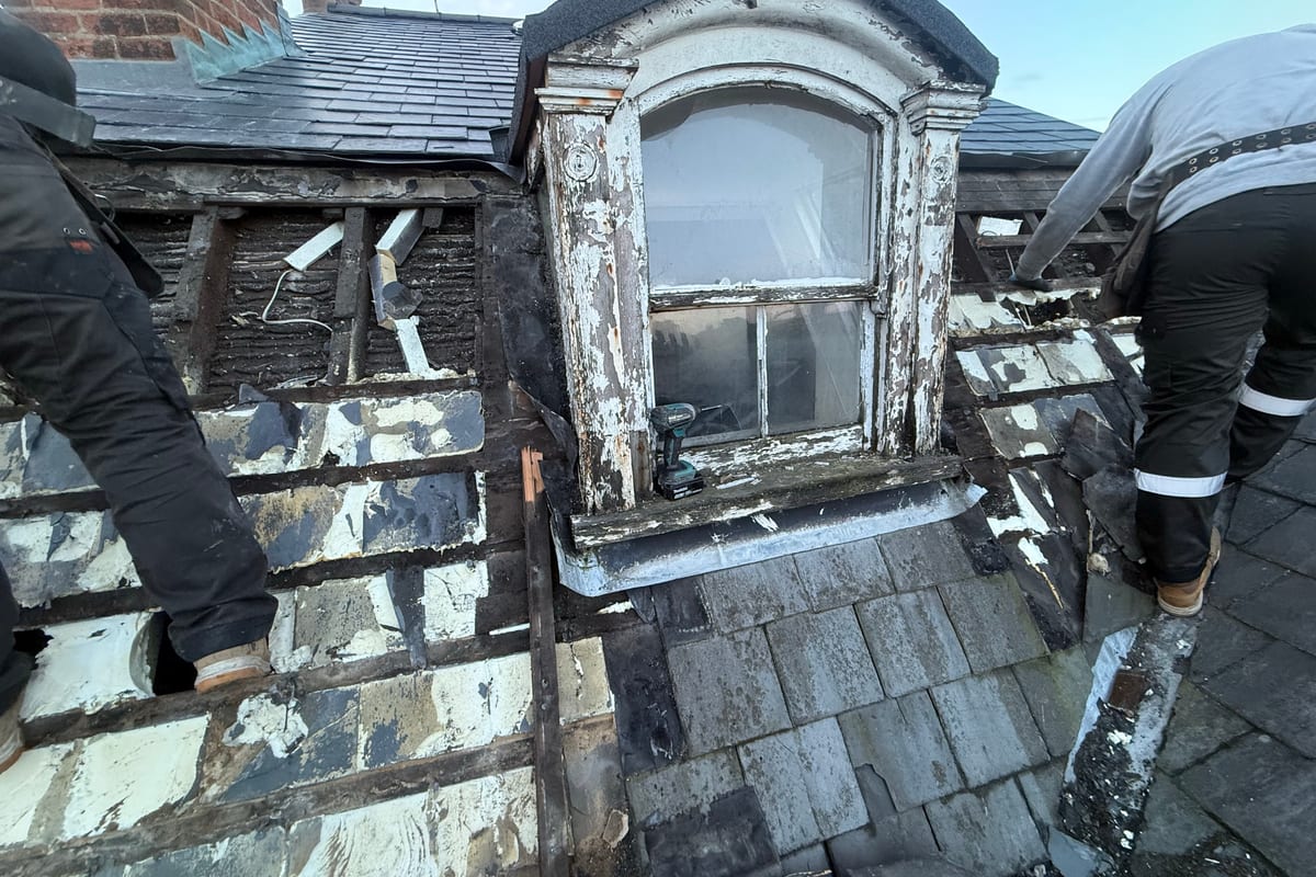 A slate roof opened up around a dormer for repair