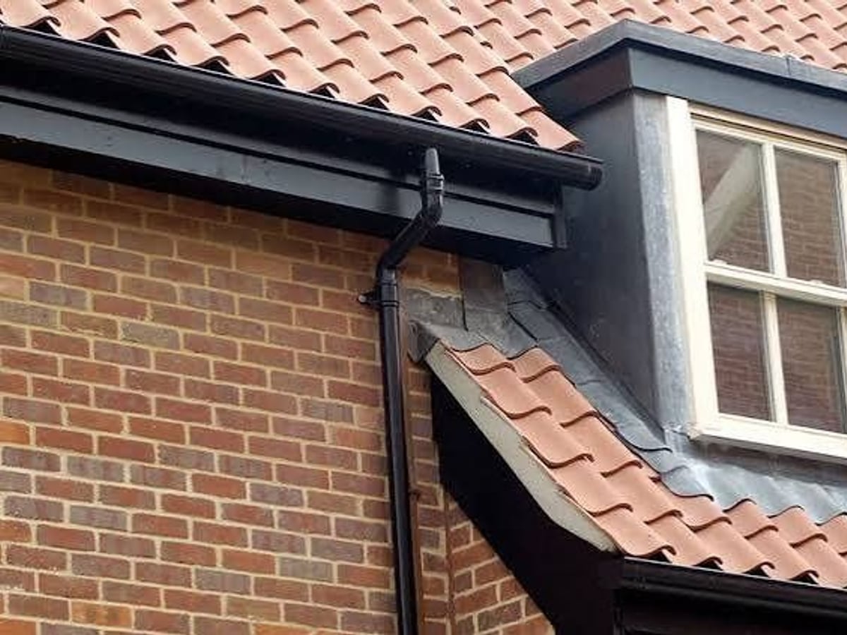 Black aluminium fascia, gutter and downpipe on a brick house