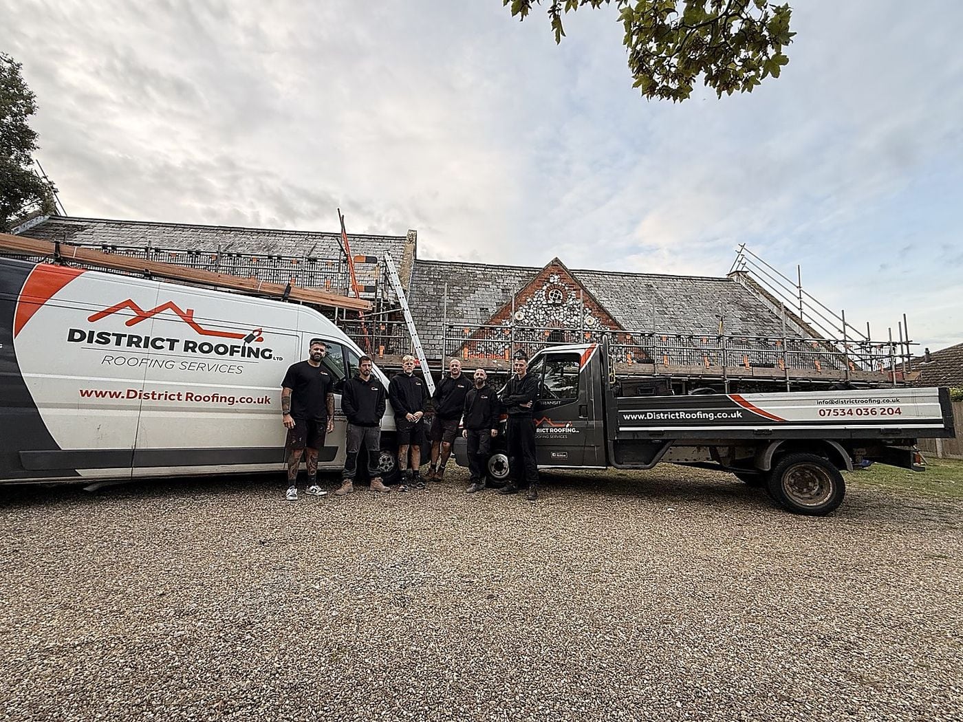 The District Roofing team with their van and truck, on site in front of a slate roof