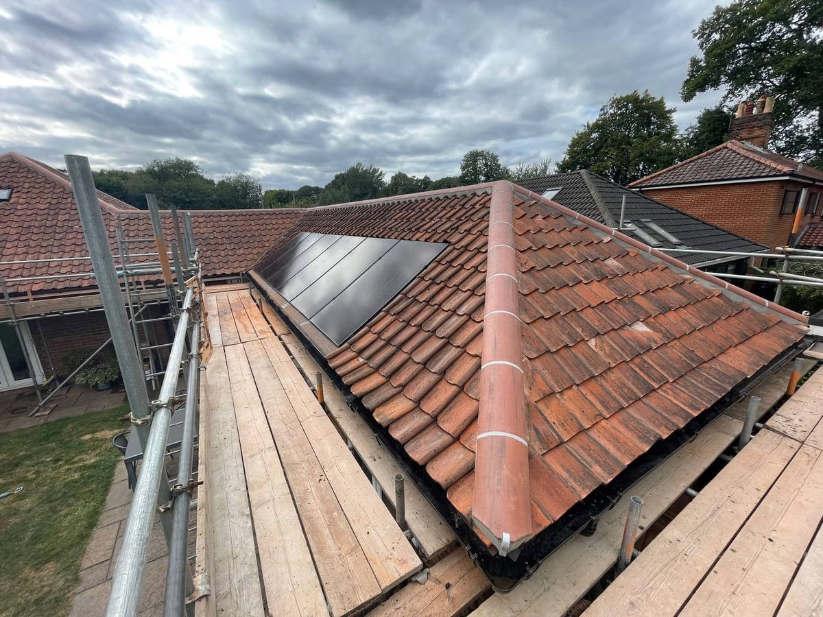 Solar panels on a clay tile roof, with scaffolding still up